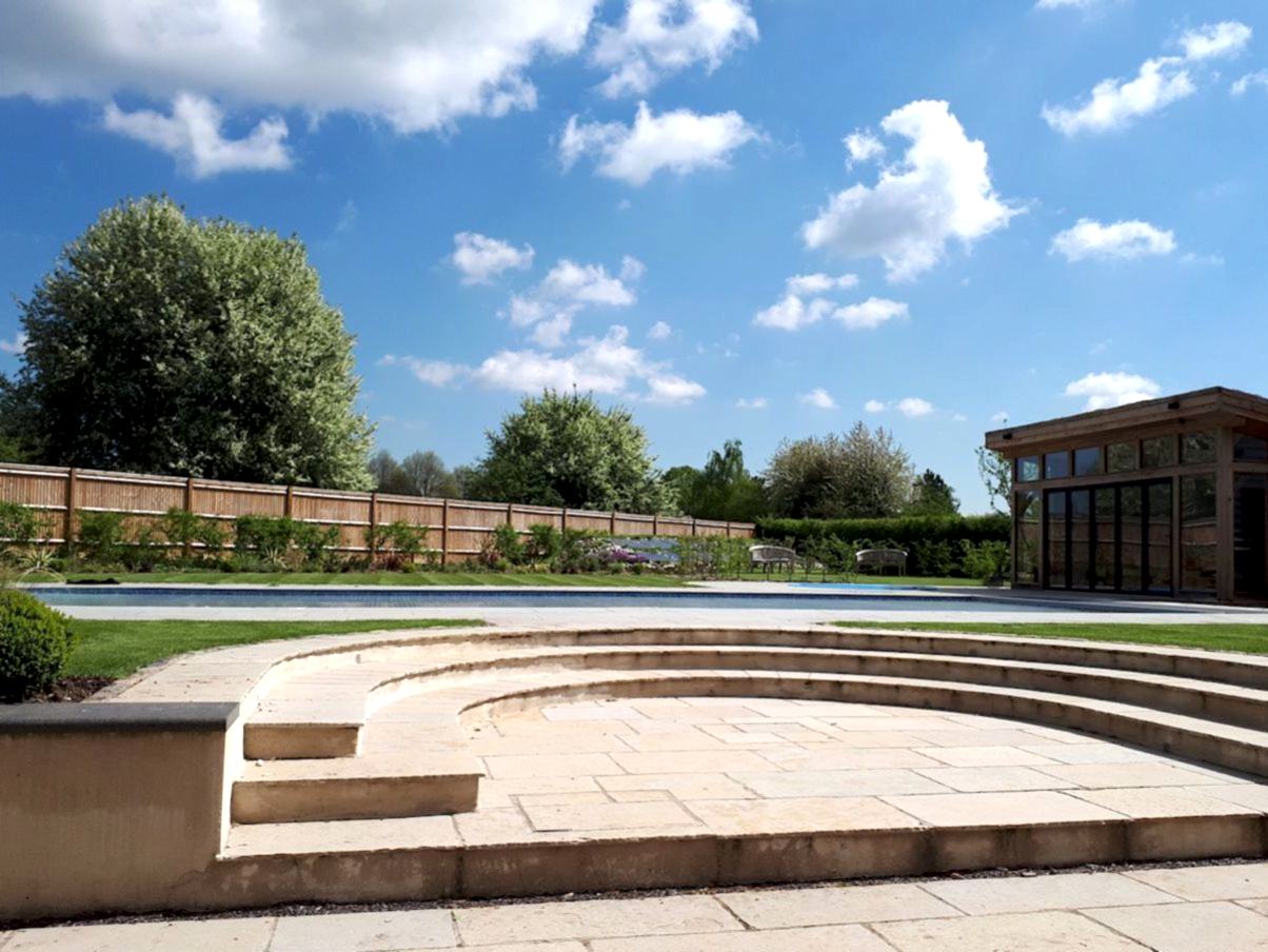 Garden design in Denham, Buckinghamshire with raised pool terrace and curved steps.