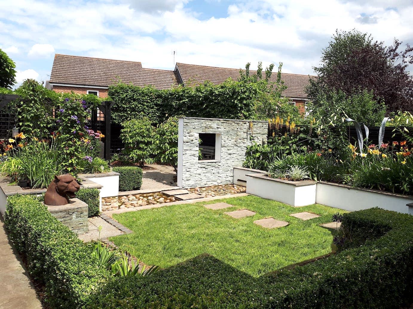 Garden design in Bracknell, Berkshire with feature wall, raised beds, sunken seating area and raised beds.