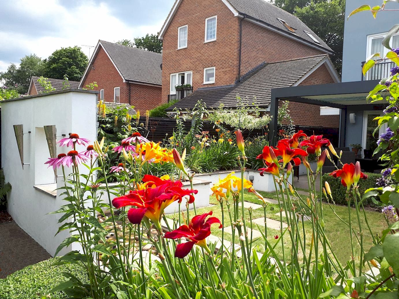 Garden design in Bracknell, Berkshire with feature wall, raised beds and water feature.