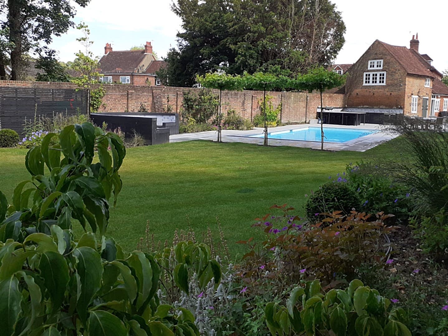 Garden design in Windsor Berkshire with swimming pool and outdoor kitchen