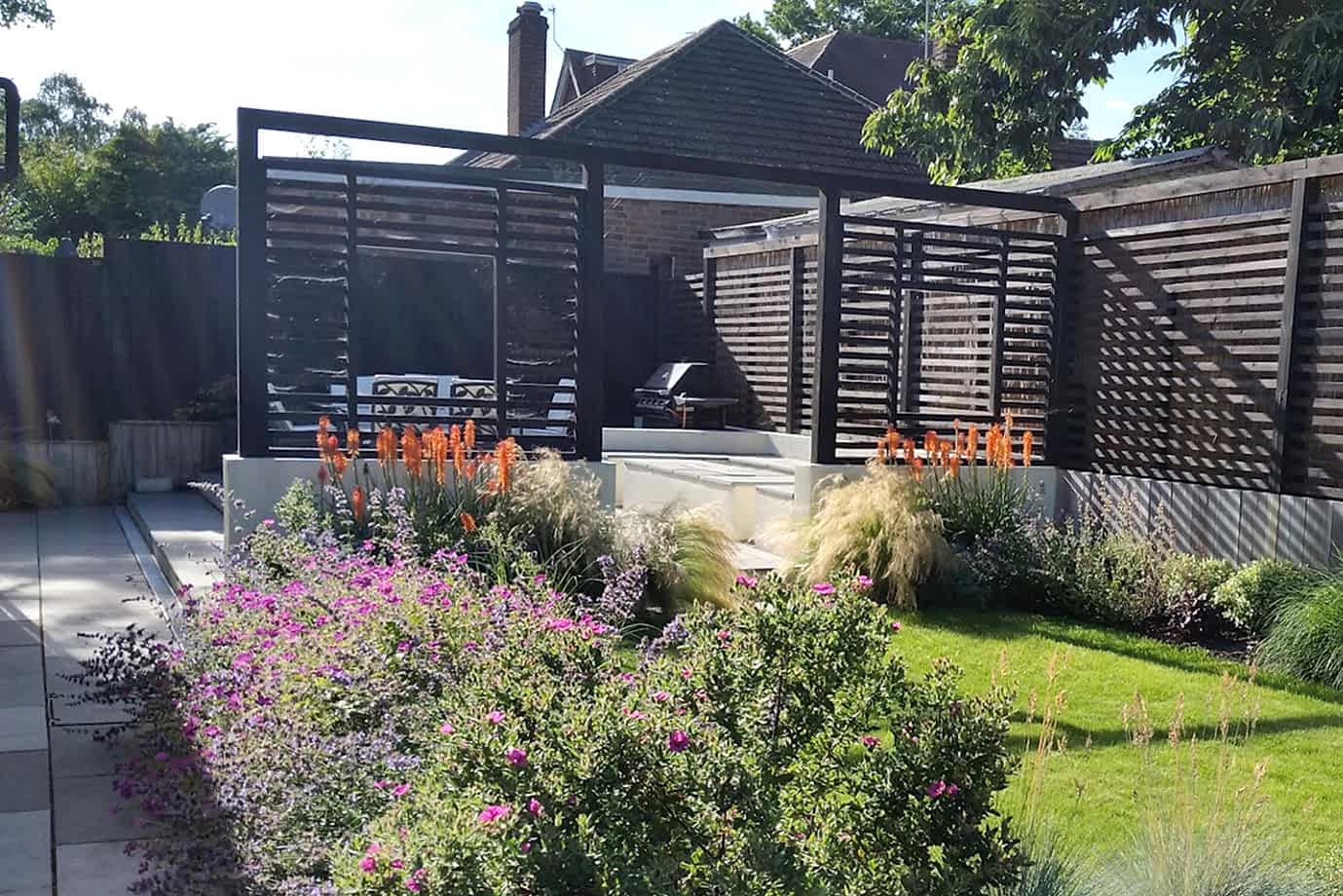 Garden design in Crowthorne, Berkshire with outdoor rooms, fireplace, pergola and terraced levels.