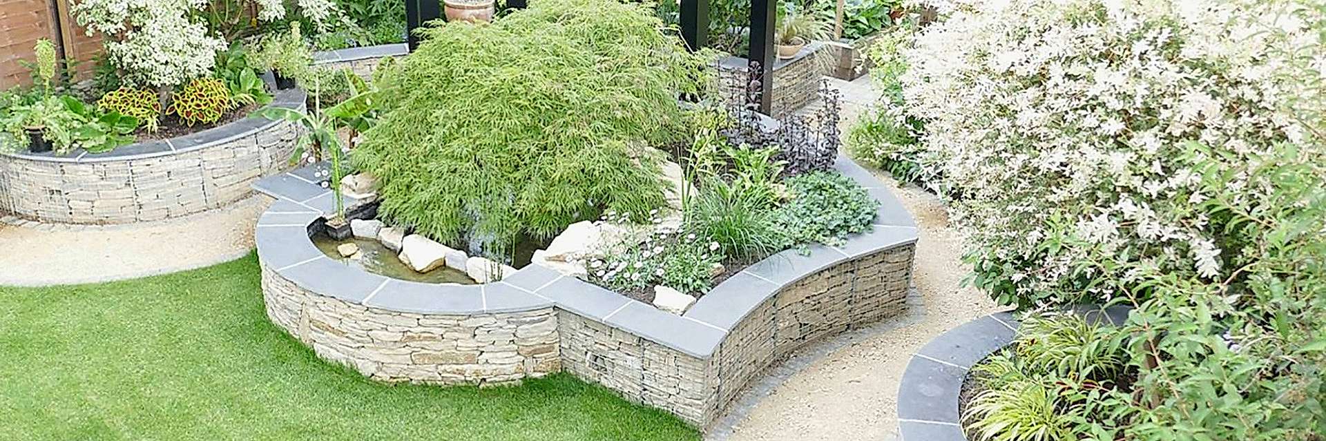 Garden design in St Albans, Hertfordshire with gabion retaining walls and a steel pergola.